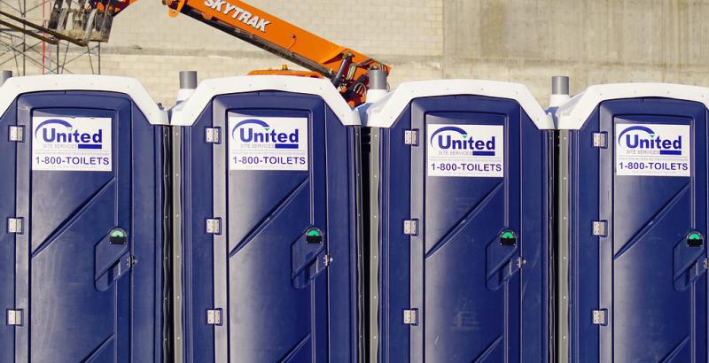 four united site service porta potties at a construction site