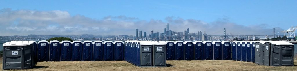 many many porta potties set up at an outdoor event