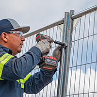 a worked putting together a temporary fence